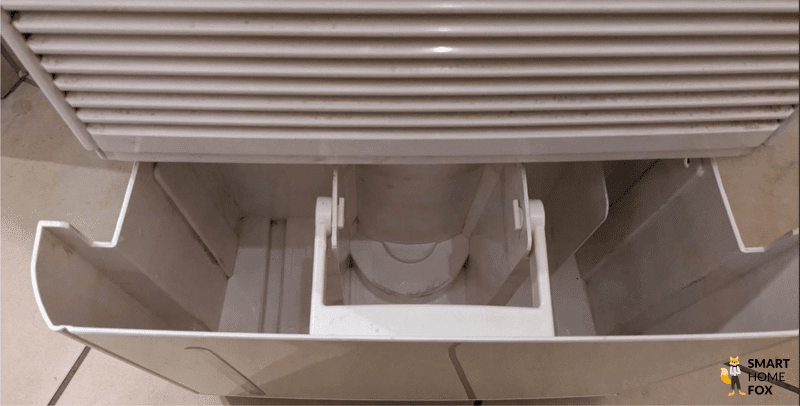 Der Trotec TTK 90 E Luftentfeuchter steht auf dem Boden und der Wassertank steht direkt vor dem Gerät.